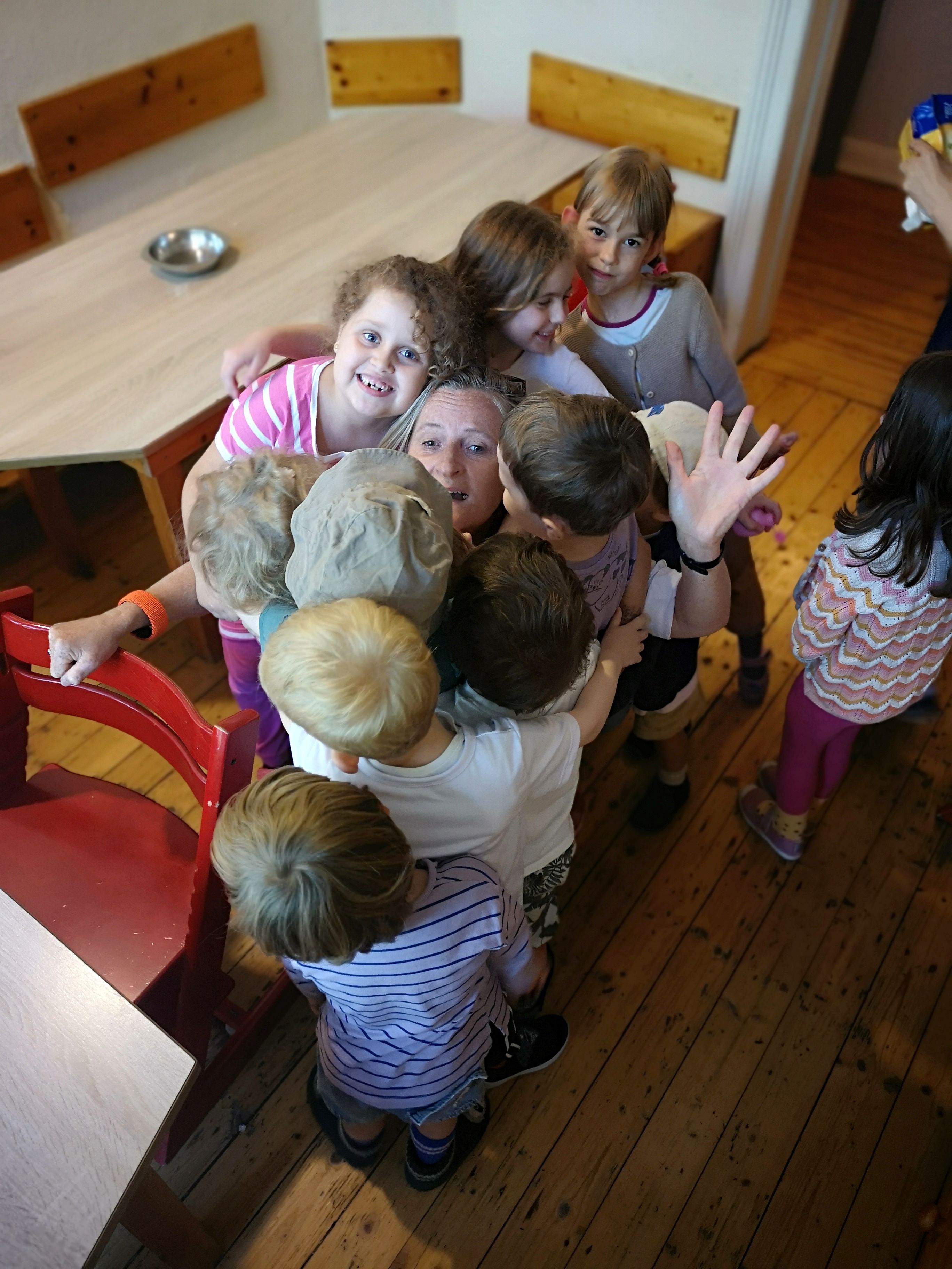 Kinderumarmungskette um Pädagogin