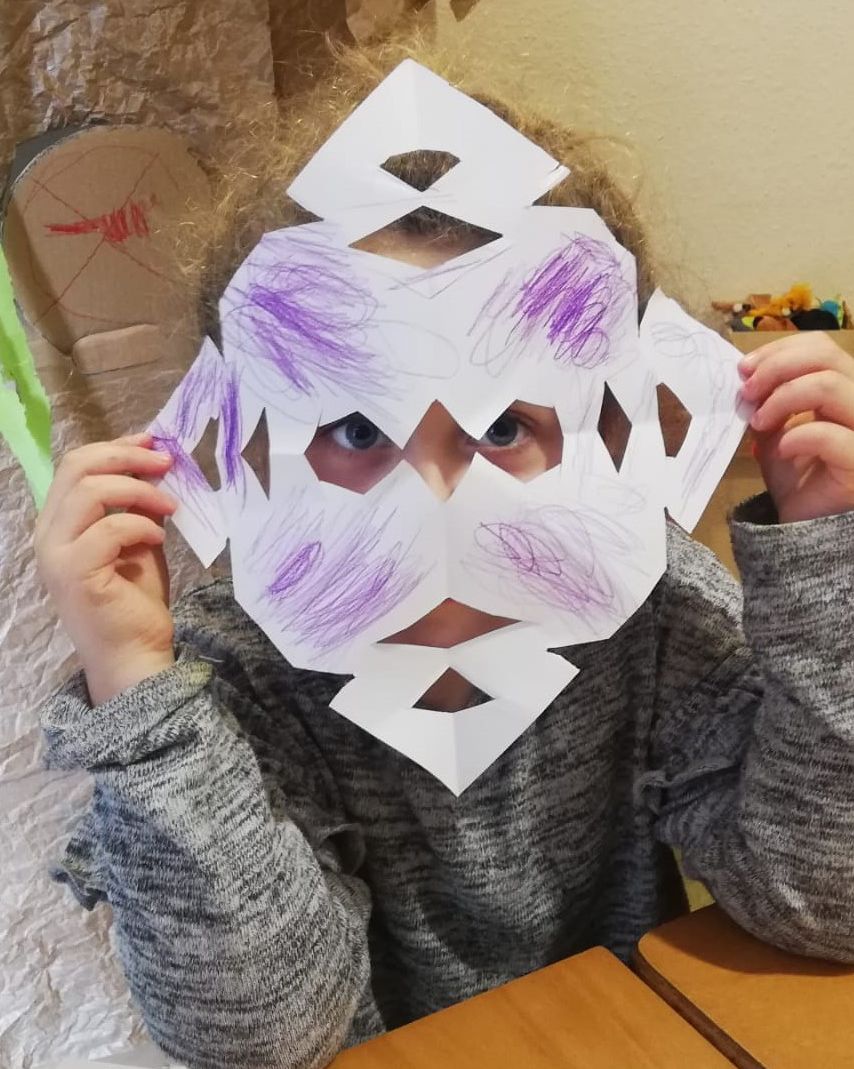 Kind mit selbstgemachter Papiermaske